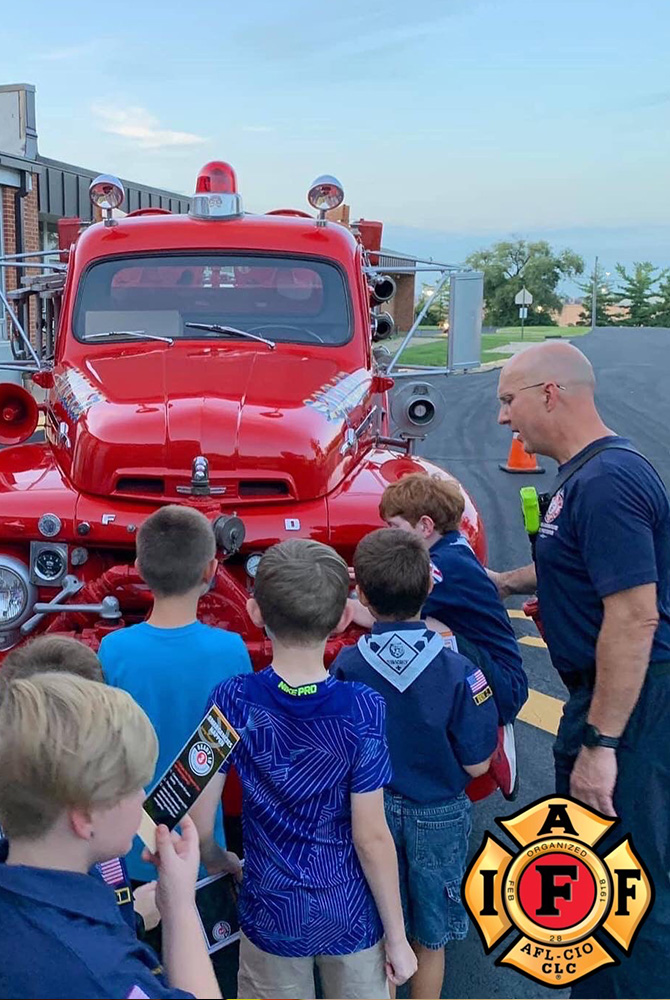 Fireman visiting school with vintage firetruck